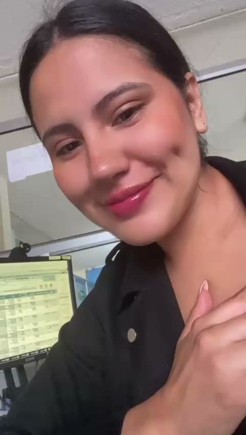 Smiling woman with dark hair talking into her front camera